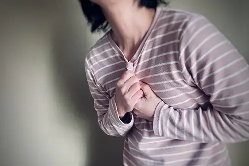 胸を抑えて痛がる人