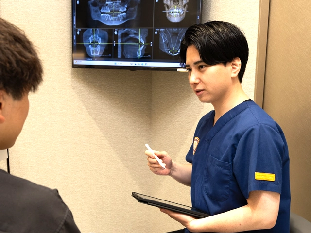 患者様に症状を説明する歯科医師